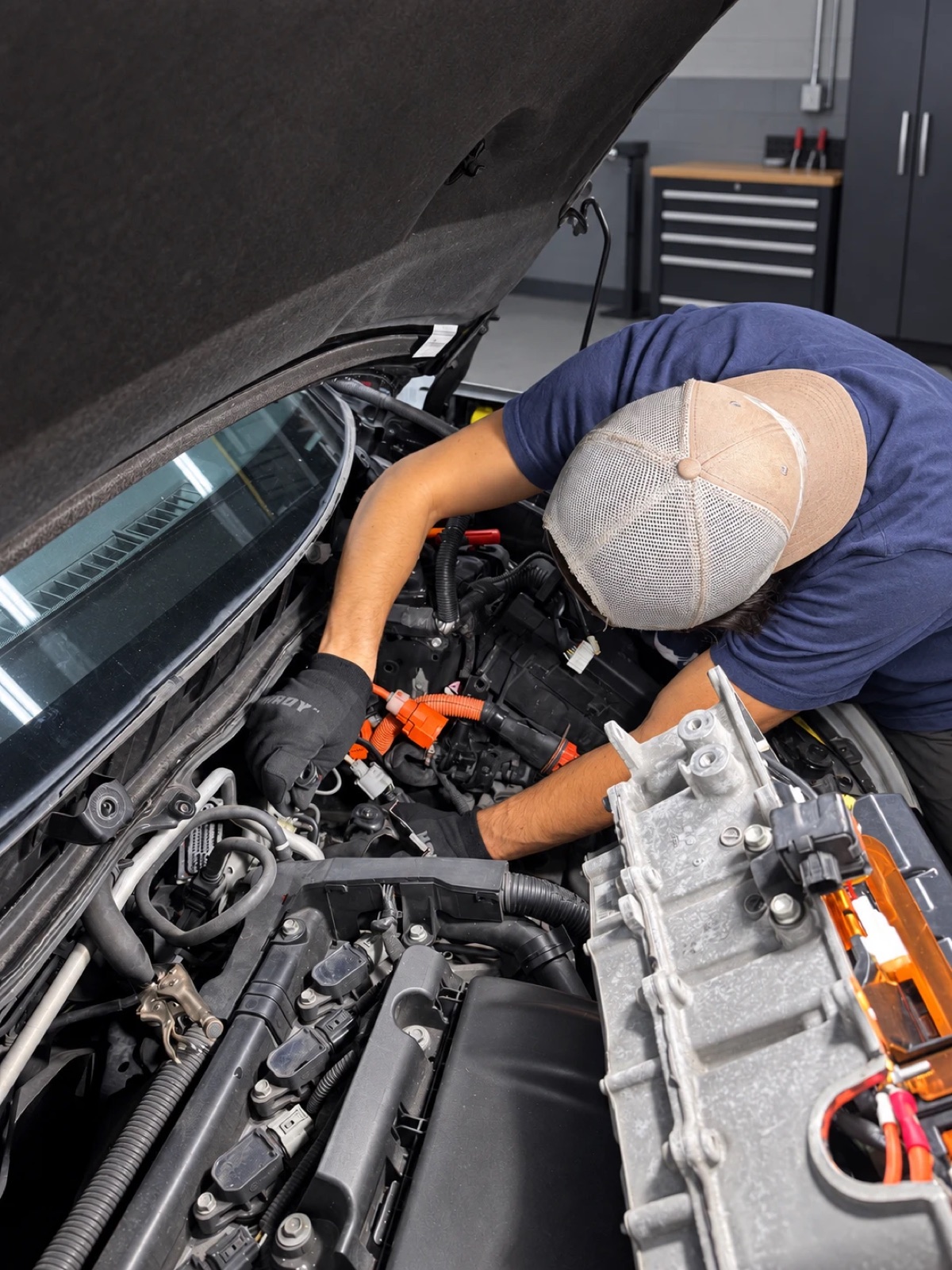 Technician working under the hood of a Prius